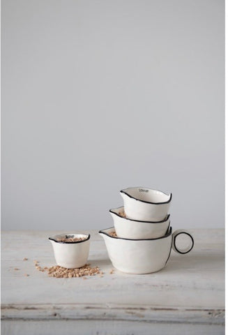 This rustic set of measuring cups are made of stoneware, they are white with a black rim on the edges with a little pour spout.  The set looks nice nested together. These measuring cups would make a perfect gift for a home chef or baker.